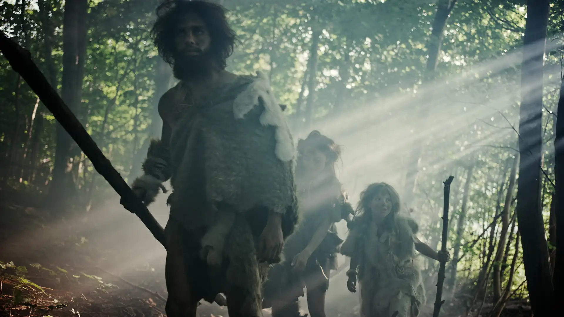 Early humans moving through a forest